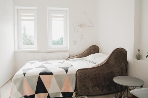 ein Schlafzimmer mit einem Bett mit einer karierten Decke in der Unterkunft Kivi apartamentai Palangoje in Palanga