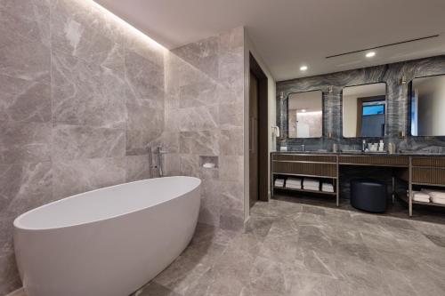 a bathroom with a white tub and a sink at JW Marriott Charlotte in Charlotte