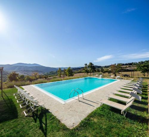 a swimming pool with lounge chairs and a swimming poolituresitures at Residenza le Colline del Paradiso in Bivigliano