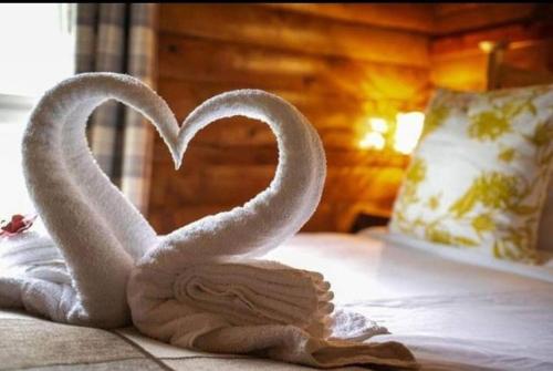 two towels shaped like swans sitting on a bed at Grouse Lodge in Dunoon