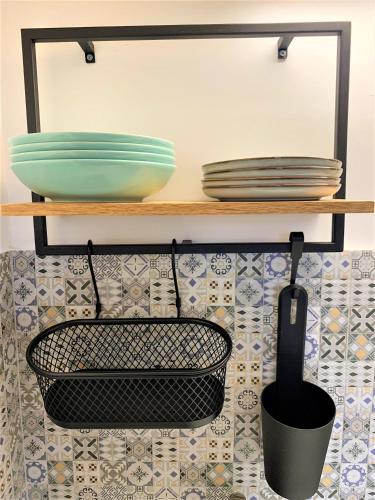 a kitchen with plates and bowls on a shelf at 1900 Vetus Central Apartment in Cluj-Napoca