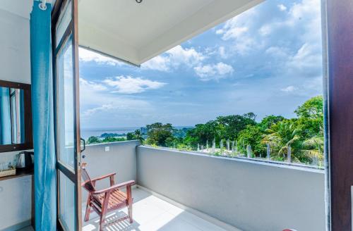 a room with a balcony with a view of trees at Kapaliya Unawatuna in Unawatuna