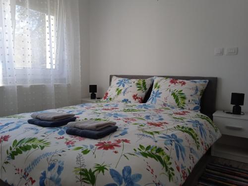 a bed with a floral bedspread with two pillows on it at Seoski turizam Stari mlin na Korani room 2 in Karlovac