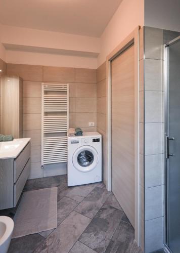 a bathroom with a washing machine and a sink at Bellavista Apartments in Lenno