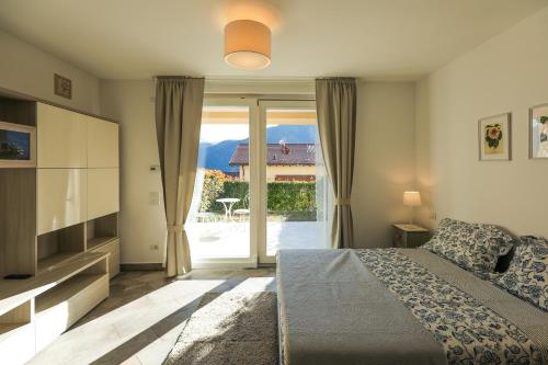 1 dormitorio con 1 cama y puerta corredera de cristal en Bellavista Apartments, en Lenno