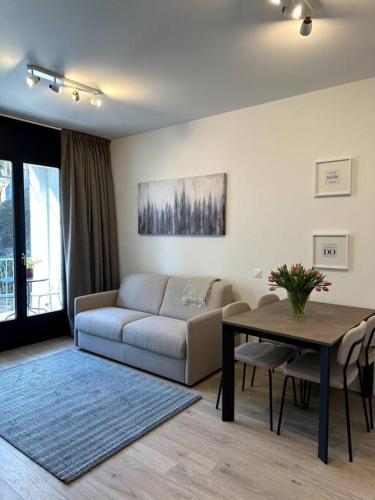 ein Wohnzimmer mit einem Sofa und einem Tisch in der Unterkunft Riva 5 in Lugano