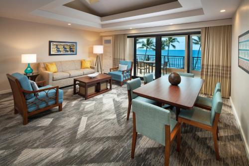 Sheraton Kauai Resort في كولو: غرفة معيشة مع طاولة وكراسي وأريكة