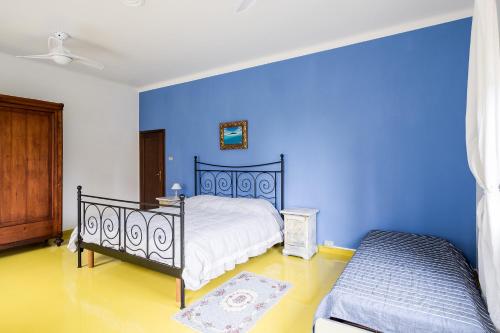 een slaapkamer met een bed en een blauwe muur bij R&B La Villa in Bologna