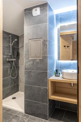 une salle de bain avec douche et lavabo dans l'établissement TERRESENS - Le Snoroc, à Aime La Plagne
