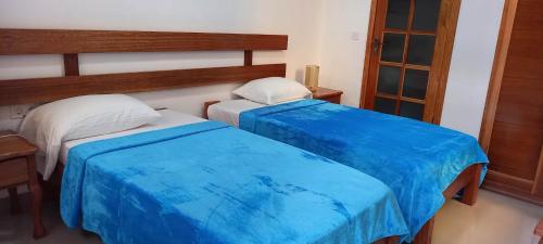 Duas camas sentadas uma ao lado da outra num quarto em Hotel Viajante em Tarrafal