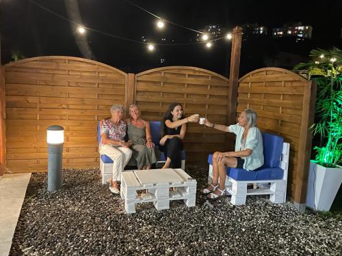 a group of women sitting on chairs on a patio at Les Créolines in Sainte-Luce