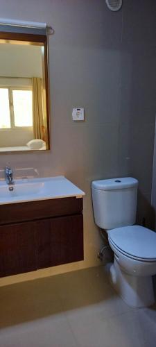 a bathroom with a toilet and a sink and a mirror at Hotel Viajante in Tarrafal