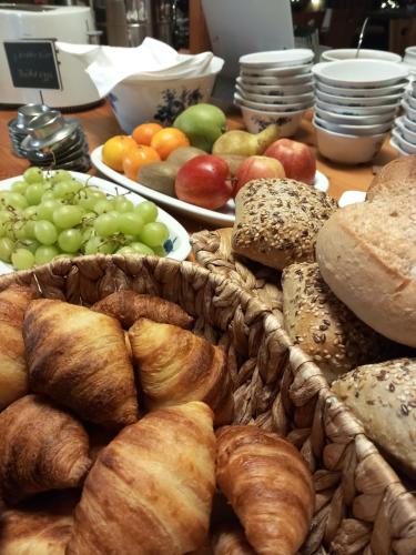 a table topped with plates of bread and pastries at Vintage Hotel Petrisberg in Trier