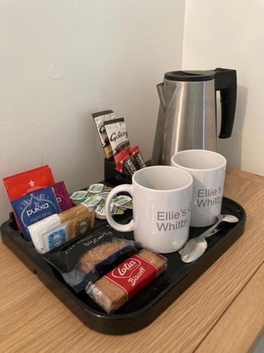 a tray with coffee cups and other items on a table at Ellies Guest House in Whitby