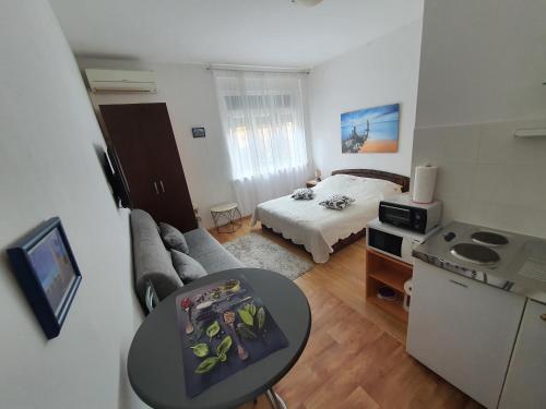 a small living room with a bed and a table at Apartment Martea in Split