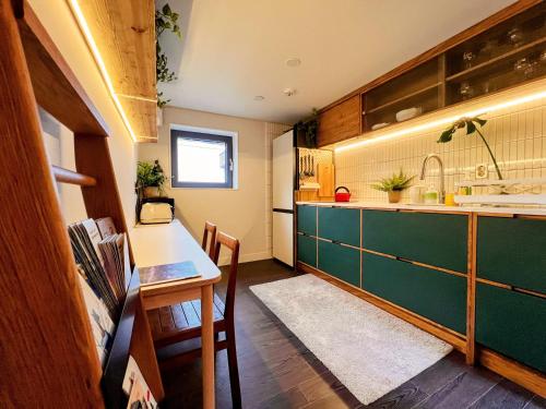 a kitchen with a green counter and a table at HHZib, homestay on a hill in the heart of Seoul in Seoul