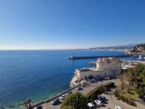 a building by the water with cars parked at Hotel Le Saint Paul in Nice