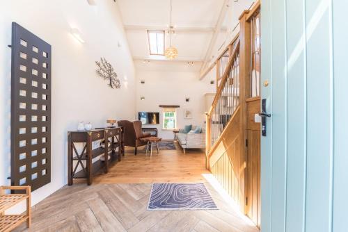 a hallway with a staircase and a living room at Mill Pool Barn Torver, Coniston in Coniston