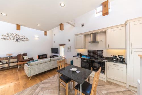 a kitchen and living room with a table and chairs at Mill Pool Barn Torver, Coniston in Coniston