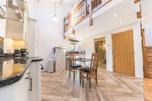 a kitchen with a table and chairs in a room at Mill Pool Barn Torver, Coniston in Coniston