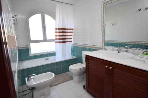 a bathroom with a sink and a toilet and a mirror at Seaviews Balcones de Chaparral 3 Bed Apt in Mijas Costa