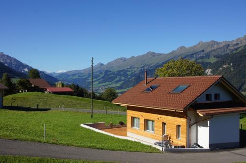a house with a red roof with mountains in the background at Gästehaus myHideaway in Reichenbach