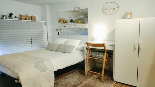 um pequeno quarto com uma cama e uma cadeira em Estudio DuplexBCN em Barcelona