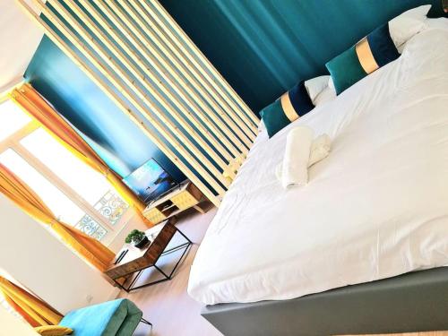 une chambre avec un grand lit et une fenêtre dans l'établissement Le Cosy Central Moderne et Chaleureux, à Saint-Étienne