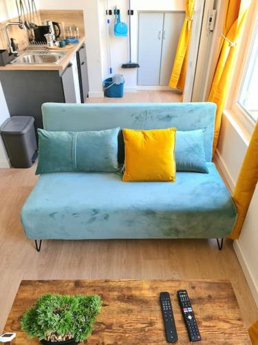 - un canapé bleu dans le salon avec deux télécommandes dans l'établissement Le Cosy Central Moderne et Chaleureux, à Saint-Étienne