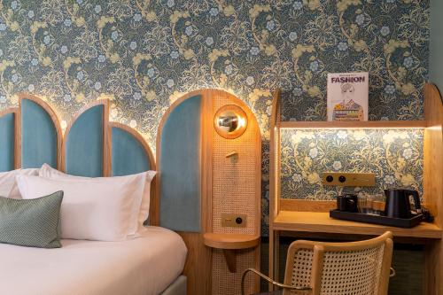 a bedroom with a bed and a wall with floral wallpaper at Hôtel Jardin de Cluny in Paris