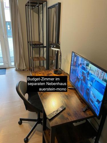 a desk with a computer monitor and a laptop on it at AUERSTEIN-Hotels auerstein & auerstein-mono in Heidelberg