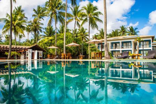 una piscina frente a un complejo con palmeras en Vivant Eco Beach OFICIAL en Barra Grande
