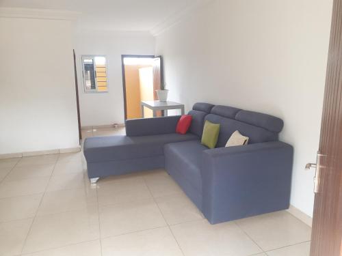 a blue couch in a living room with a mirror at Lovely 1-Bed duplex house in Abidjan