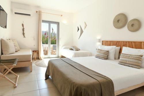 a bedroom with a bed and a chair and a window at Paros Bay in Parasporos