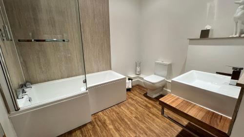 a bathroom with a tub and a sink and a toilet at The Gower Hotel in Swansea