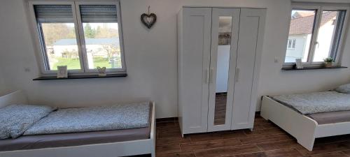 a room with two beds and two windows at Große tolle 4 Zimmer Ferienwohnung im Herzen des Odenwaldes in Mörlenbach