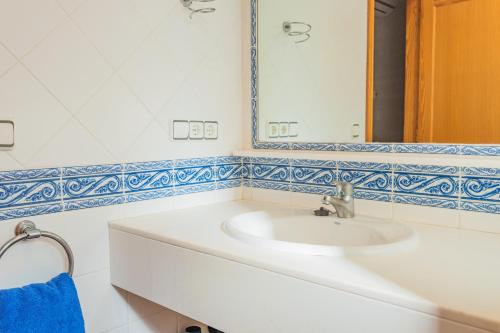y baño con lavabo blanco y espejo. en Villa Llebeig 155TS Son Bou By MENORCARENTALS, en Son Bou