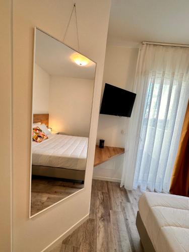 a mirror in a bedroom with a bed and a television at Ca' Maggiolo in Cinto Caomaggiore