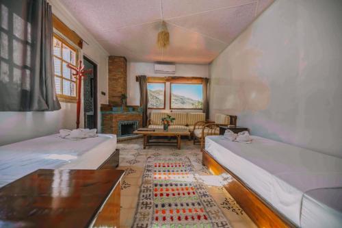 a room with two beds and a table in it at Dar l'eau Vive in Bine el Ouidane