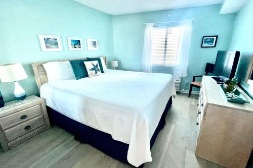 a blue bedroom with a large bed and a television at Perdido Sky 72 in Perdido Key