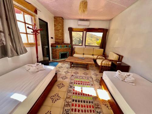 a bedroom with two beds and a living room at Dar l'eau Vive in Bine el Ouidane