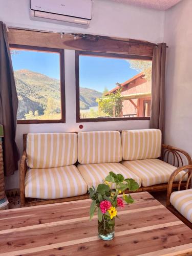 a living room with a couch and a table with flowers at Dar l'eau Vive in Bine el Ouidane
