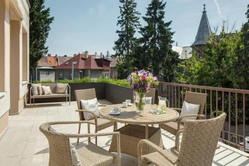 a patio with a table and chairs on a balcony at Mamaison Residence Sulekova Bratislava in Bratislava