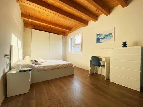 1 dormitorio con cama, escritorio y silla en Sol Lakeview, en Sale Marasino