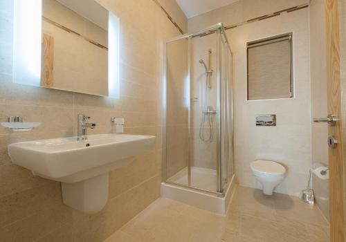 a bathroom with a sink and a shower and a toilet at Seafront Apartment Sliema in Sliema
