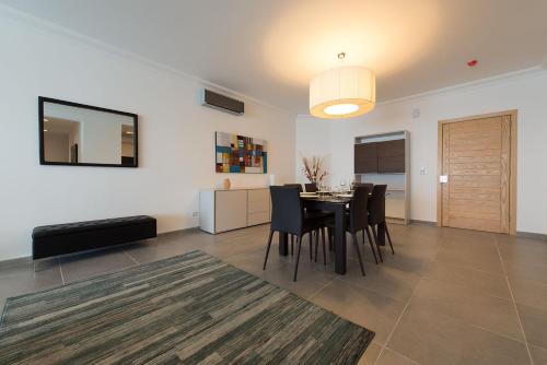 a dining room and living room with a table and chairs at Seafront Apartment Sliema in Sliema