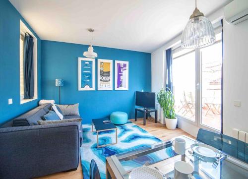 Sala de estar azul con sofá y mesa en Modern penthouse close to Gran Via ~ Big Terrace~, en Madrid