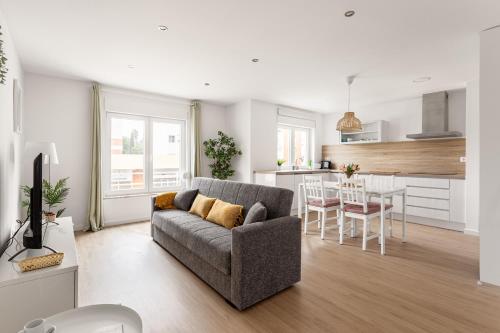 a living room with a couch and a kitchen at Lisbon Vibes - Monsanto house in Lisbon