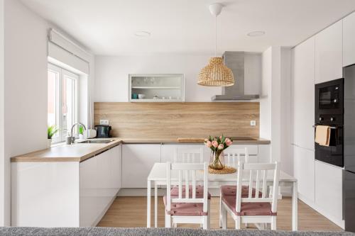 a kitchen with white cabinets and a table with chairs at Lisbon Vibes - Monsanto house in Lisbon