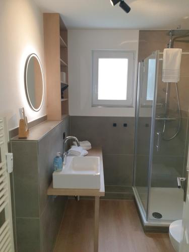 a bathroom with a sink and a shower at Design-Suite am See in Ascheberg